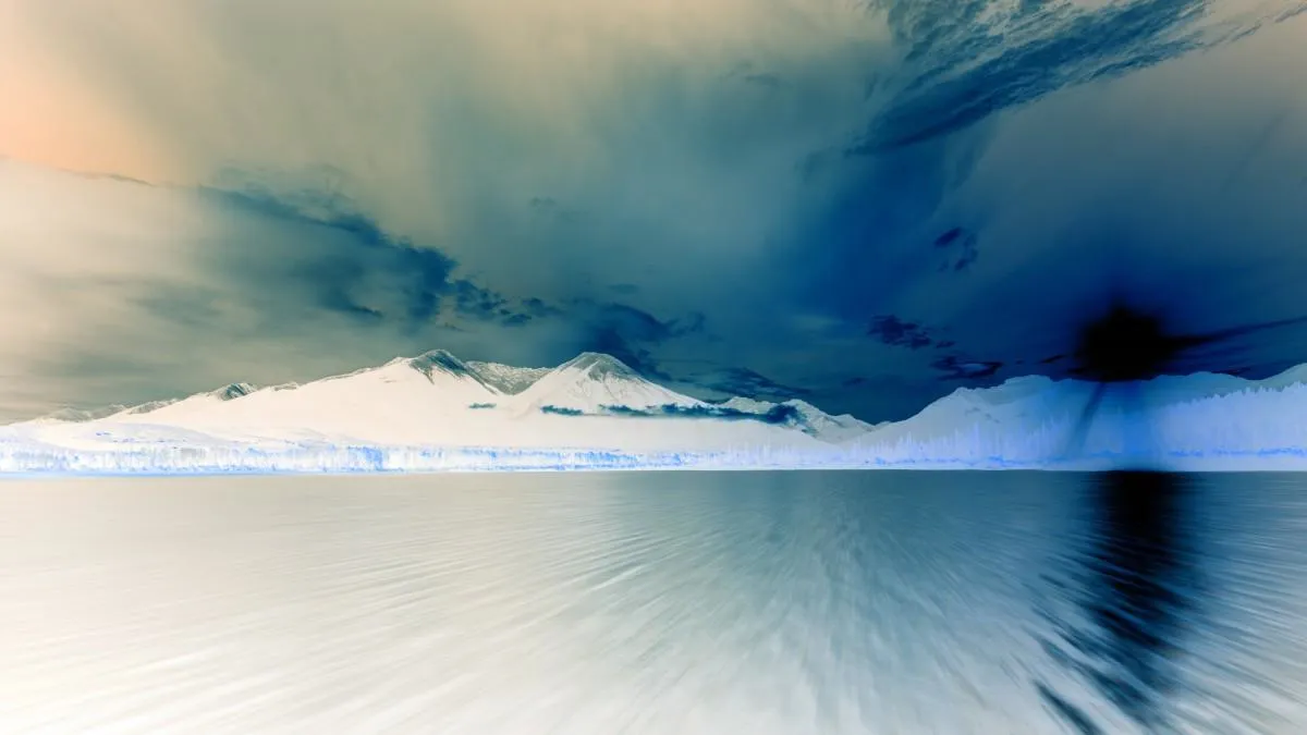 Distant mountains at sunset viewed from the horizon, with colors inverted